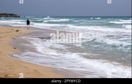 Personne non reconnue qui marche sur une plage de sable tropical. Activités de plein air. Vagues venteuses et orageuses. Protaras Chypre Banque D'Images