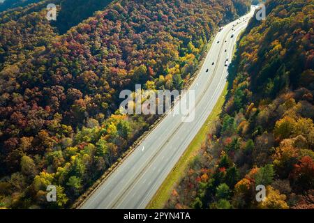 I-40 route d'autoroute menant à Asheville en Caroline du Nord en traversant les montagnes Appalaches avec forêt d'automne jaune et camions et voitures rapides. Concept o Banque D'Images