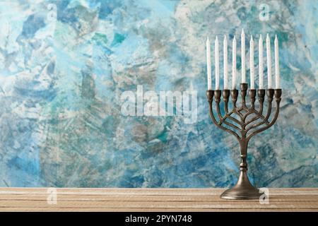Bonne Hanoukkah. Hanoukkah vieille Menorah sur fond de drapeau israélien avec lumière du soleil ou bokeh sur fond de bois blanc. Image religieuse de jewis Banque D'Images