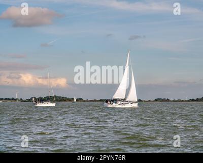 Personnes en voilier naviguant sur le lac Ijsselmeer au large de la côte de la Frise, pays-Bas Banque D'Images