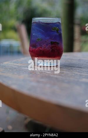 Portrait ou photo verticale d'une boisson fraîche à base de fruits aux fraises combinée avec du thé bleu à base de Clitoria Ternatea, généralement connue sous le nom de Pea FL aux papillons Banque D'Images