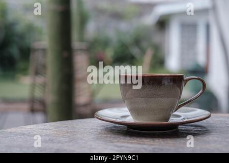 Une tasse de café en porcelaine sur une table en bois. Bokeh ou arrière-plan flou. Banque D'Images