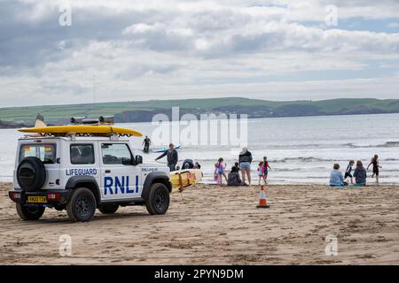 RNLI, maître-nageur, surveille les familles et les surfeurs sur Bigbury sur la plage de sable de la mer, South Devon, Royaume-Uni Banque D'Images