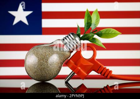 Bouchon, plante poussant à l'intérieur de l'ampoule et drapeau du Libéria. Concept d'énergie renouvelable écologique. Banque D'Images