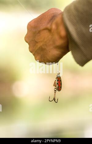 Une image verticale d'une personne avec une canne à pêche en main, prête à enrouler dans sa prise Banque D'Images