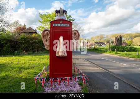 4 mai 2023. Une boîte phonebox décorée et amusante quelques jours avant le couronnement du roi Charles III et de la reine Camilla. Les décorations irrévérencieuses du village de Compton, en Angleterre, au Royaume-Uni, comprennent de grandes oreilles saillantes et un nez avec une couronne. Banque D'Images