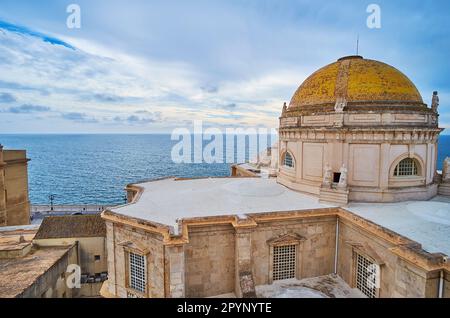 Dôme historique de la cathédrale Sainte-Croix contre le ciel nuageux et les eaux ondulées de l'océan Atlantique, Cadix, Espagne Banque D'Images