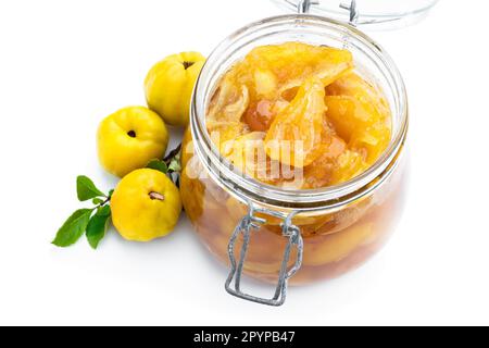 Confiture de coing maison dans des pots en verre et coing frais avec des feuilles isolées sur blanc Banque D'Images