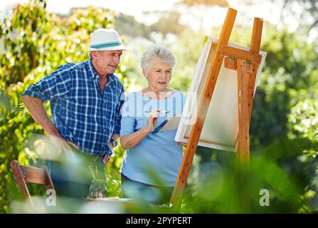 Sa peinture sera parfaite. un couple senior peint dans le parc. Banque D'Images