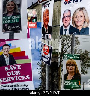 Montage d'affiches électorales pour les prochaines élections locales en Irlande du Nord, d'affiches pour Sinn Fein, TUV, SDLP, UParti et le Parti travailliste Banque D'Images