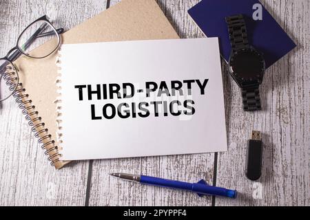 Texte LIVRAISON PAR UN TIERS écrit sur un livre blanc avec un stylo et des lunettes sur un clavier d'ordinateur.concept d'entreprise. Banque D'Images