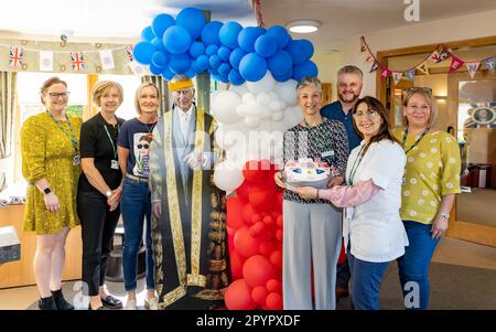 4 mai 2023 - Warrington, Cheshire, Angleterre, Royaume-Uni. Le personnel de l'Hospice de St Rocco s'est préparé pour le King Charles II Coronation en décorant le bâtiment avec des drapeaux, des banderoles et des décorations de porte. Le personnel de l'Hospice pose avec son gâteau de couronnement avec une découpe en carton du roi Charles. L'Hospice de St Rocco s'occupe des personnes et de leurs familles qui ont reçu un diagnostic de maladie qui limite leur vie, leur permettant de bien vivre et vers la fin de leur vie ont une mort digne dans un lieu de leur choix. Crédit : John Hopkins/Alay Live News Banque D'Images