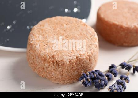 Barres de shampooing solides et fleurs de lavande sur table blanche, gros plan Banque D'Images