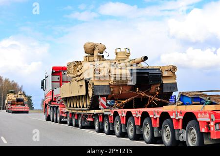 Transport de charge exceptionnel du char militaire américain M1 Abrams en circulation. Convoi de véhicules de trois transports de citernes. Lieto, Finlande. 28 avril 2023. Banque D'Images