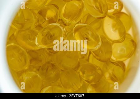 beaucoup de capsules de gélatine jaune sur fond clair. vitamines omega, gros plan, macro. Banque D'Images