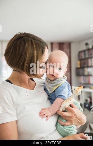 Mère aimante embrassant son bébé sur la joue, Bavière, Allemagne Banque D'Images