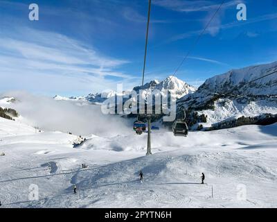 DE LA SÉRIE ADELBODEN téléphérique dans la neige en face du paysage viticole à Adelboden, Oberland bernois, canton de Berne, Suisse. La ville pittoresque d'Adelboden est une idylle suisse dans les Alpes bernoises, des sommets impressionnants, un paysage d'hiver unique, un domaine skiable populaire, des pâturages alpins, cascades jaillissantes, maisons en bois confortables. En raison du changement climatique et de moins en moins de neige, le complexe sportif classique d'hiver se réoriente et la saison estivale devient de plus en plus importante Banque D'Images