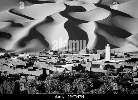 Algérie, Kerzaz. Sandsea de l'Ouest (Grand Erg Occidental). Vallée de Gourara. Désert du Sahara. Vue panoramique sur les dunes de sable, le village, l'oasis et les palmiers. B Banque D'Images