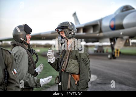 Les pilotes de chasse combattent les combinaisons de vol sous pression et les appareils respiratoires à l'oxygène avec l'avion Vulcan Bomber XM 655 à Wellesbourne Airfield, Angleterre, Royaume-Uni Banque D'Images
