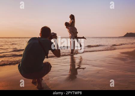 portrait de mariage photographe prenant des photos de couple de lune de miel sur la plage au coucher du soleil, photographie professionnelle Banque D'Images
