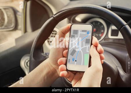 Le conducteur utilise la navigation de direction sur la carte GPS sur l'écran du smartphone mobile dans la voiture Banque D'Images