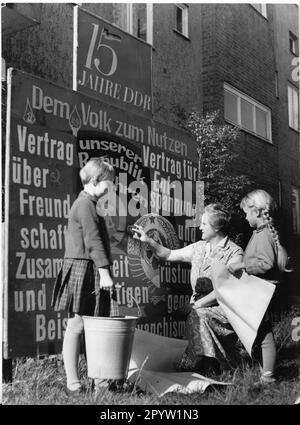 'Potsdam 1964 préparatifs pour la Fête de la République, une image de propagande typique, légende originale: ''le nettoyage de fête de la Fête de la République commence également dans les zones résidentielles. Au 29 de la rue Paul-Neumann-Strasse à Babelsberg. Le camarade Martin met les touches de finition sur un présentoir. Marlis et Erwin étaient très serviables.'' GDR. historique. Photo: MAZ/Manfred Haseloff, 1964 [traduction automatique]' Banque D'Images