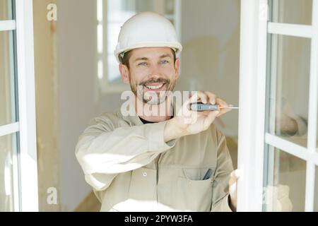 L'homme à l'aide de tournevis sur la fenêtre Banque D'Images