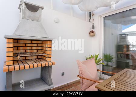 Barbecue écologique moderne sur la terrasse de l'appartement avec une table. Banque D'Images