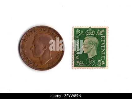 Pièce de monnaie à moitié penny et timbre du règne du roi George VI isolé sur un fond blanc. Banque D'Images