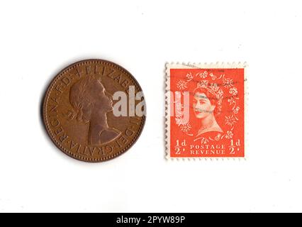 Une pièce de monnaie d'un demi-cent et un timbre du règne de la reine Elizabeth II isolés sur un fond blanc. Banque D'Images