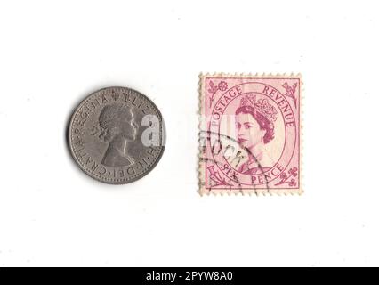 Sixpence pièce et timbre du règne de la reine Élisabeth II isolé sur fond blanc. Banque D'Images