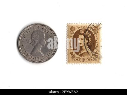 Une pièce de monnaie et un timbre renversant du règne de la reine Elizabeth II isolés sur un fond blanc. Banque D'Images