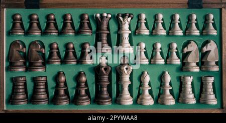 Une collection de pièces d'échecs disposées dans une caisse en bois Banque D'Images