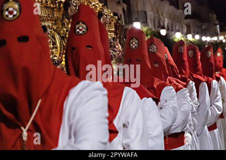 Nazarenos portant des capots rouges portent une plate-forme massive avec une statue de Jésus-Christ pendant la procession silencieuse de minuit commençant le Vendredi Saint à la semaine Sainte ou Semana Santa, 6 avril 2023 à Ronda, Espagne. Ronda, établie pour la première fois au 6th siècle avant Jésus-Christ, organise des processions de la semaine Sainte depuis plus de 500 ans. Banque D'Images