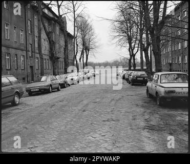 Rue avec voitures garées, arbres et maisons en hiver. Wildau, quartier de Dahme-Spreewald, Brandebourg. Photo, 1993. Banque D'Images