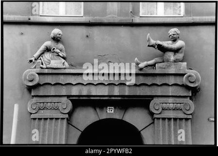 Zittau, Allemagne de l'est, ancien GDR. Façade de maison, art en construction. Vue partielle: Homme et femme comme sculpture en pierre, vie quotidienne, Figures au-dessus du portail d'entrée. Vue sur la ville, noir et blanc. Photo, 1992. Banque D'Images