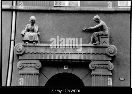 Zittau, Allemagne de l'est, ancien GDR. Façade de maison, art en construction. Vue partielle: Homme et femme comme sculpture en pierre, vie quotidienne, Figures au-dessus du portail d'entrée. Vue sur la ville, noir et blanc. Photo, 1992. Banque D'Images