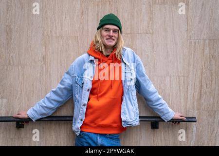 Joyeux boxeur millénaire portant des vêtements en denim souriant à l'appareil photo tout en passant du temps à l'extérieur Banque D'Images