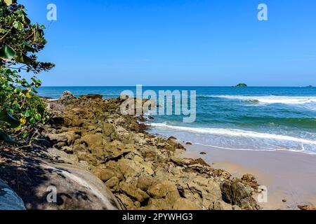 Pierres avançant dans la mer sur une plage paradisiaque à Bertioga sur la côte de l'état de Sao Paulo, Brésil, Brésil Banque D'Images