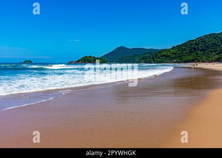 Plage paradisiaque entourée de forêt tropicale et de collines par une journée ensoleillée à Bertioga sur la côte de Sao Paulo, Bertioga, Sao Paulo, Brésil Banque D'Images