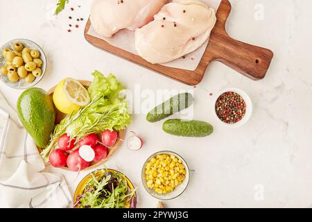 Cétogène, Paleo, FODMAP, concept de régime. Fruits, légumes, viande de poulet, légumes verts sur planche à découper en bois Banque D'Images