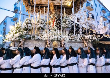 Nazarenos portant des chapeaux verts porte une plate-forme massive avec une statue de la Vierge Marie dans une procession pendant la semaine Sainte ou Santa Semana, 5 avril 2023 à Ronda, Espagne. Ronda, établie pour la première fois au 6th siècle avant Jésus-Christ, organise des processions de la semaine Sainte depuis plus de 500 ans. Banque D'Images