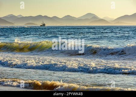 Lever du soleil sur la plage du diable à Ipanema à Rio de Janeiro avec un bateau de pêche et des montagnes en arrière-plan., Brésil Banque D'Images