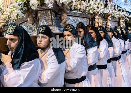 Nazarenos portant des chapeaux verts porte une plate-forme massive avec une statue de la Vierge Marie dans une procession pendant la semaine Sainte ou Santa Semana, 5 avril 2023 à Ronda, Espagne. Ronda, établie pour la première fois au 6th siècle avant Jésus-Christ, organise des processions de la semaine Sainte depuis plus de 500 ans. Banque D'Images