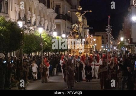 Les Cofradias portant des capuches en forme de cône rouge mènent une plate-forme géante avec la Crucifixion pendant la procession silencieuse de minuit marquant le Vendredi Saint à la semaine Sainte ou le Père Noël Semana, 6 avril 2023 à Ronda, Espagne. Ronda, établie pour la première fois au 6th siècle avant Jésus-Christ, organise des processions de la semaine Sainte depuis plus de 500 ans. Banque D'Images