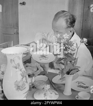 L'homme peint la porcelaine avec des motifs de fleurs sauvages. Photo non datée d'environ 1935 Banque D'Images