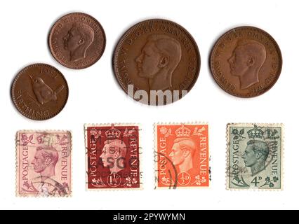 Pièces de monnaie vintage et timbres du règne du roi George VI isolé sur fond blanc. Banque D'Images