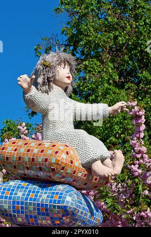 Sculpture d'un enfant assis sur la pyramide des oreillers à Pejzazhna Alley, le célèbre parc pour enfants de Kiev, Ukraine. Banque D'Images