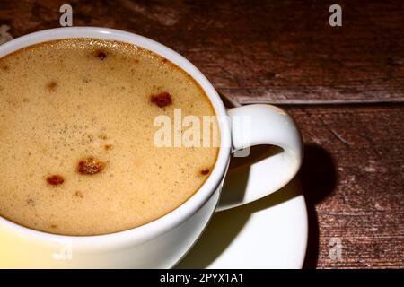 Gros plan d'une tasse de café blanc assis sur une table en bois Banque D'Images