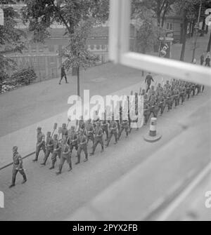 Les membres du Service du travail du Reich traversent une rue dans l'arrière-pays du Koog. Ils marchent à l'étape, pelle à la main, pour travailler dans le Koog. La photo a été prise à partir d'une fenêtre. Photographie non datée, probablement prise en 1934. [traduction automatique] Banque D'Images